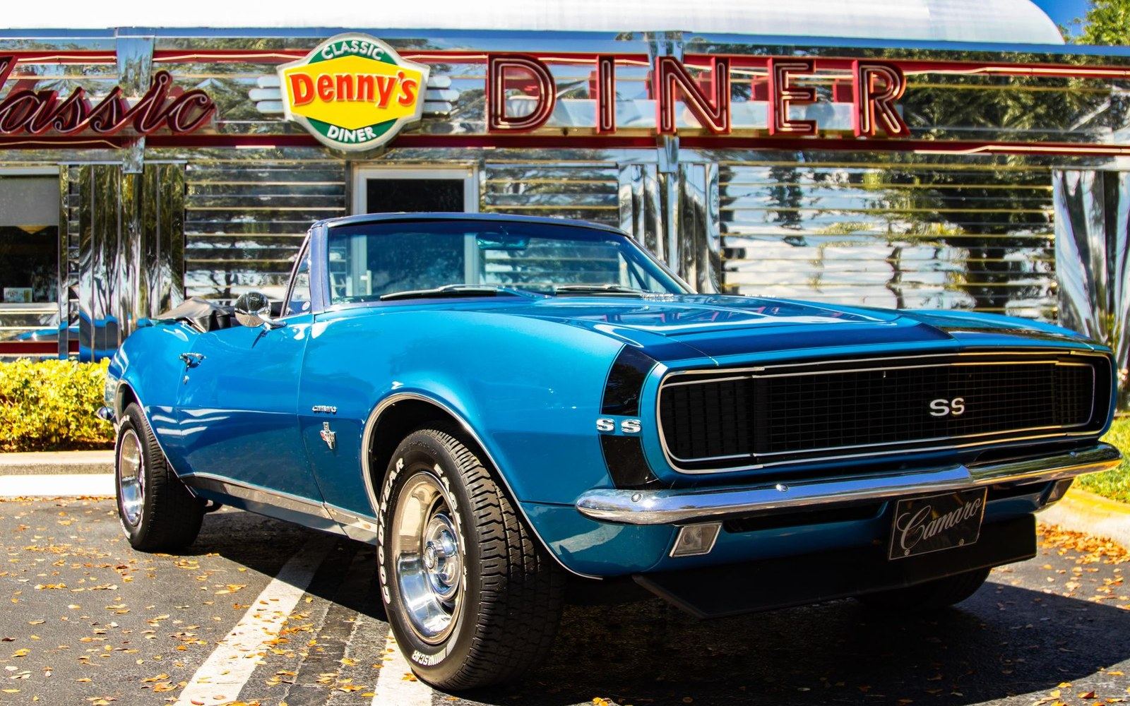A blue Camaro SS convertible parked outside a classic chrome diner